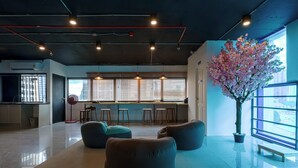 Een moderne loungehoek met zitplaatsen, een groot raam en een potplant.