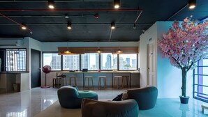 Een modern interieur met zitplaatsen, een bar en een groot raam met uitzicht op de stad.