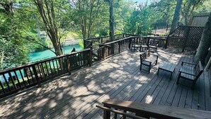 Eine Holzterrasse mit Blick auf einen See und Bäume.