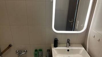 Een haardroger, handdoeken, zeep, toiletpapier