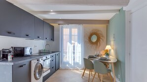 A compact kitchen with modern appliances, a dining area with a table and chairs, and a large window providing natural light. - AUTHENTIC VILLEFRANCHE AP4472 By Riviera Holiday H (Villefranche-sur-Mer)
