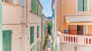 A narrow street with buildings on either side, featuring balconies and shutters. - AUTHENTIC VILLEFRANCHE AP4472 By Riviera Holiday H (Villefranche-sur-Mer)