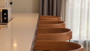 Zona de bar moderna con una barra larga y taburetes de madera.