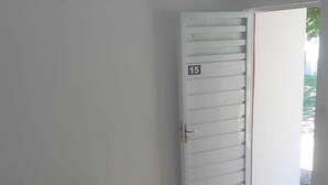 A room with a bed, a door with a number, and a view of the outside. - Pousada Estrela Mar  (Jandaira)