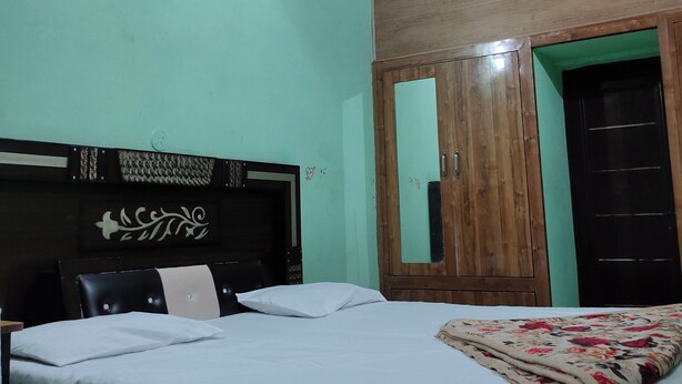 Un dormitorio con cama, armario de madera, ventilador de techo y luz empotrada.