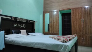 Un dormitorio con cama, armario de madera y espejo.