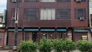 Un edificio de varios pisos con letreros que indican que es un hotel, zona de confort.