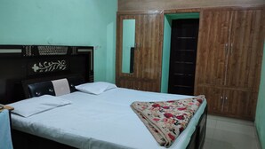 Un dormitorio con cama, armario de madera y espejo.