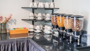 Een koffiehoek met meerdere koffieautomaten en diverse koffiecups.