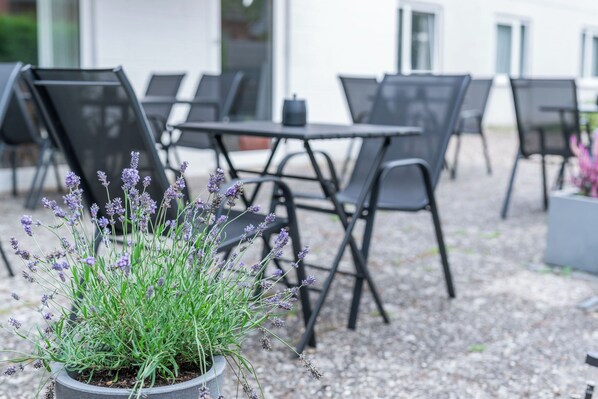 A patio area with outdoor seating and a potted lavender plant.