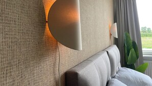 Una habitación moderna con pared texturizada, un sofá y un ventanal con cortinas.