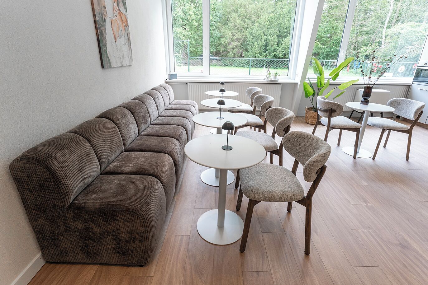 Bright communal space with comfortable seating and plenty of natural light — perfect for relaxing, working, or enjoying a meal.