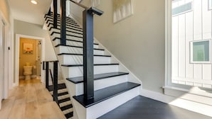 A staircase with black railings and white steps, leading to a room with a window and a door. - Walk to Dtwn Shops & Eats: St Augustine Haven! (St. Augustine)
