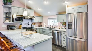 Una cocina moderna con una isla central, electrodomésticos de acero inoxidable y lavavajillas integrado.