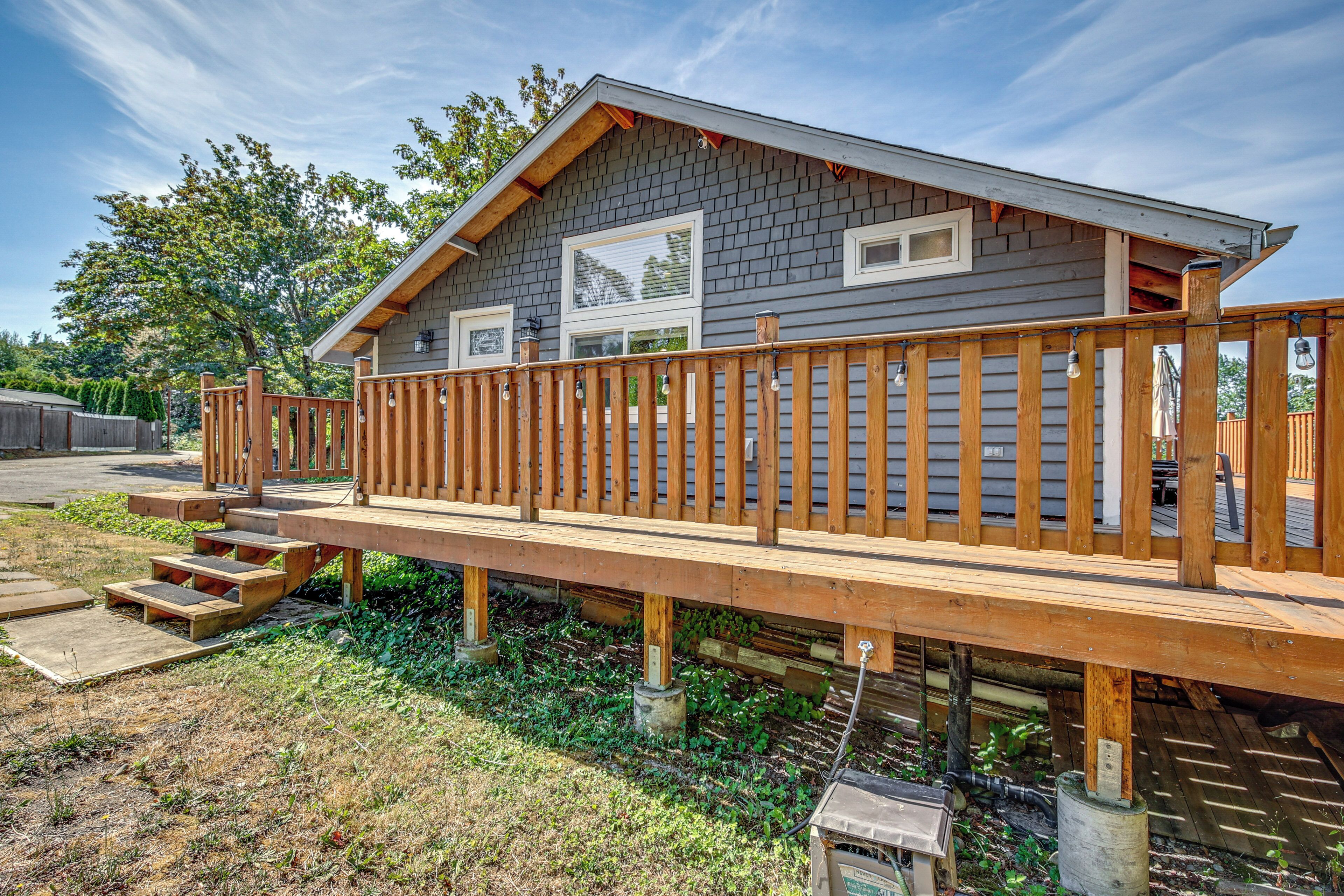 A two-story house with a wooden deck, a small porch, and a garage.