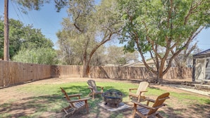 A backyard with a fire pit, wooden chairs, and a wooden fence. - 1 Mi to Texas Tech: Home w/ Large Outdoor Space! (Lubbock)