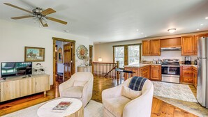 A spacious living room with a television, two sofas, a coffee table, and a ceiling fan. - Walk to River: Couples Retreat in Kintnersville! (Kintnersville)