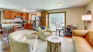 A spacious living area with a kitchen, a dining table, and a sofa. - Walk to River: Couples Retreat in Kintnersville! (Kintnersville)