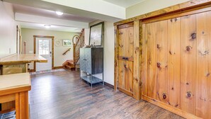 A spacious room with hardwood flooring, a wooden door, and a staircase leading to another level. - Walk to River: Couples Retreat in Kintnersville! (Kintnersville)