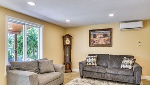 A living room with two grey sofas, a large wall clock, and a painting. - Private Outdoor Space 9 Mi to Downtown Vancouver! (Vancouver)