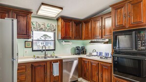 A kitchen with wooden cabinets, a stainless steel dishwasher, a microwave, and a stove.