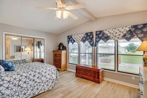 A bedroom with a bed, dresser, vanity, and large windows. - Harkers Island Getaway w/ Deck: Near Cape Lookout! (Harkers Island)