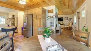 Una cocina amplia con armarios de madera, un refrigerador y un comedor con mesa y sillas.