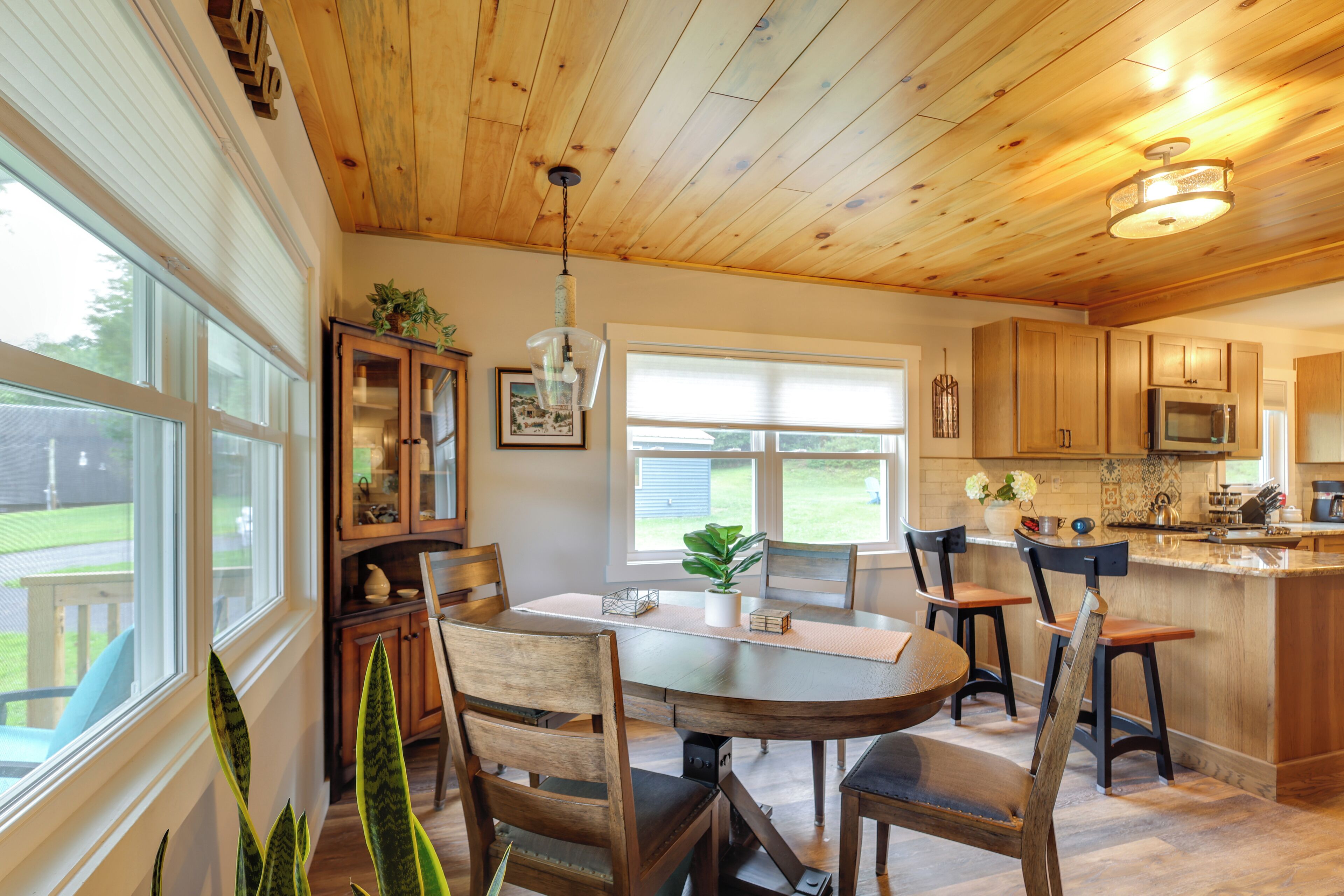 Una cocina amplia con armarios de madera, una isla central y un comedor con una mesa grande y sillas.