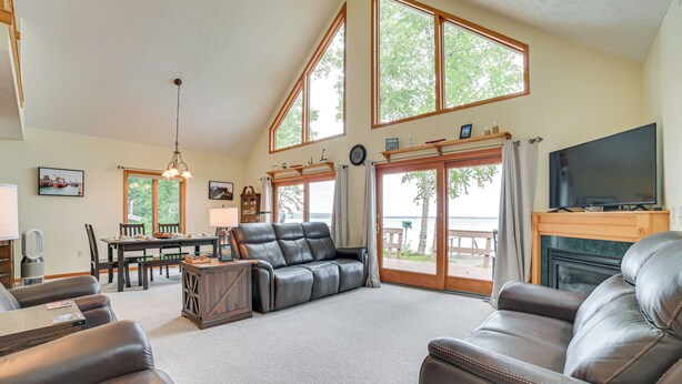 A spacious living room with leather sofas, a dining area, and a fireplace. - < 2 Mi to Brimley State Park: Lake Superior Home (Brimley)