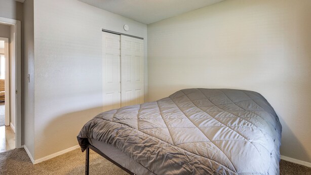 A bedroom with a bed, a ceiling fan, and a white door. - 12 Mi to St Louis: Pet-friendly Metro East Home (Granite City)