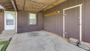 Une pièce avec un sol en béton, un plafond en bois et une fenêtre.