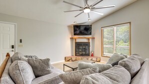 A living room with a fireplace, ceiling fan, and large window with blinds. - Lakefront Family Home 13 Mi From Gateway Arch! (Granite City)