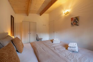 Ein Hotelzimmer mit Bett, Stuhl, Kleiderschrank und einem Bild an der Wand.