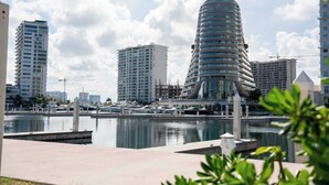 A marina with modern high-rise buildings in the background. - Modern Apt | 4BR | Marina & Beach Access (Cancún)
