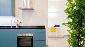 Una cucina moderna con mobili blu, una cappa aspirante in acciaio inossidabile e un forno a incasso.