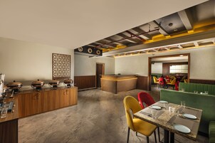 A restaurant with a counter, booths, and a reception area.