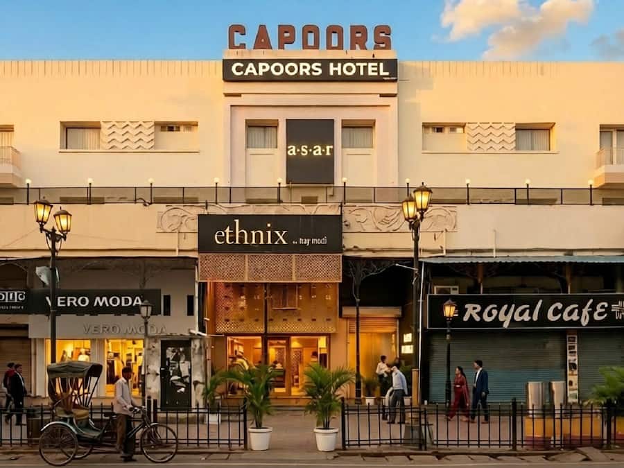 A hotel named 'Capoors Hotel' with a sign for 'ethnix' and 'Vero Moda' shops.