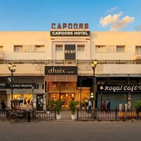 A hotel named 'Capoors Hotel' with a sign for 'ethnix' and 'Vero Moda' shops.