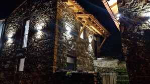A stone building with a wooden roof structure and multiple windows.