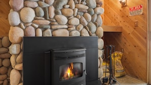 A stone wall, a fireplace with a fire, and a sign indicating a ski area boundary. - 3 Bedroom Kirkwood Condo Base Camp 3 Condo (Kirkwood)