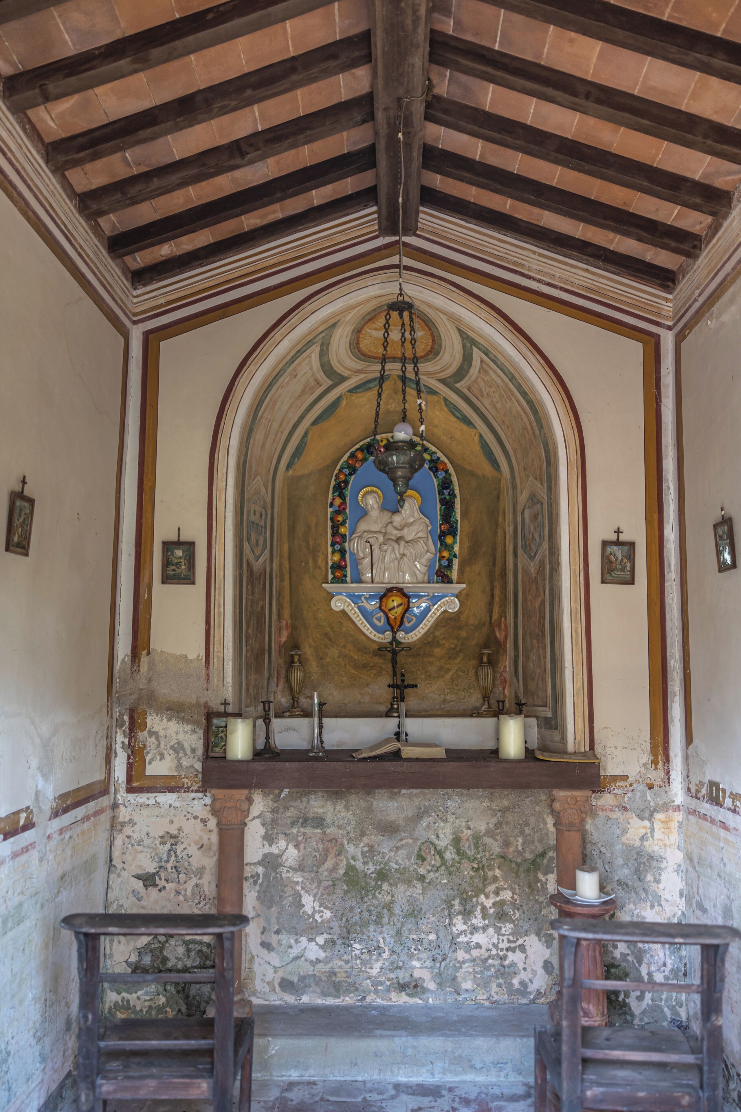 Et kirkerum med træloft, et farvet glasvindue og et træaltar.