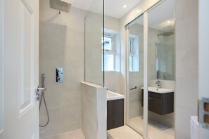 A modern bathroom with a glass shower enclosure, a white sink, and a dark wood vanity. - The Lindens Garden Retreat (Taplow)