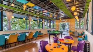 A room with a pool table, purple and yellow chairs, and a billiards table. - goSTOPS Mussoorie Clock Tower (Mussoorie)