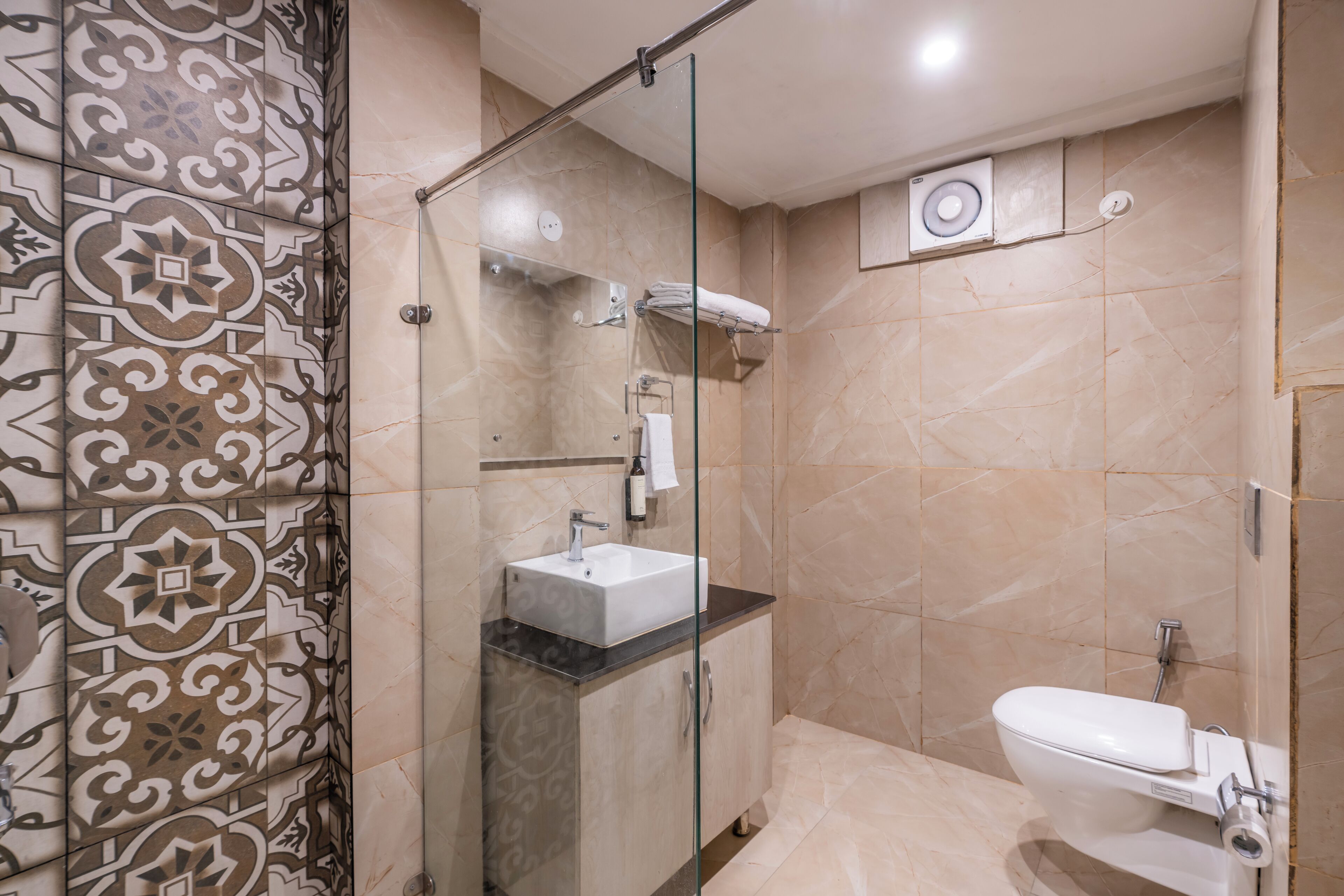 Un baño con ducha de vidrio, lavamanos e inodoro.