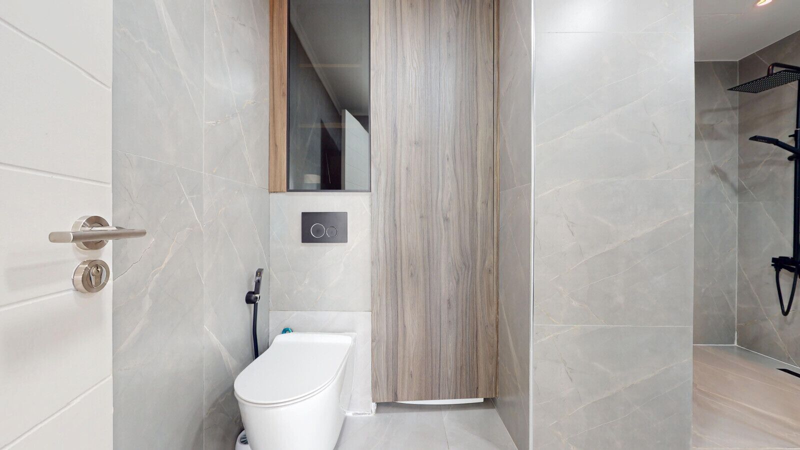 Een moderne badkamer met toilet, een wand van houten panelen en een douchegedeelte.