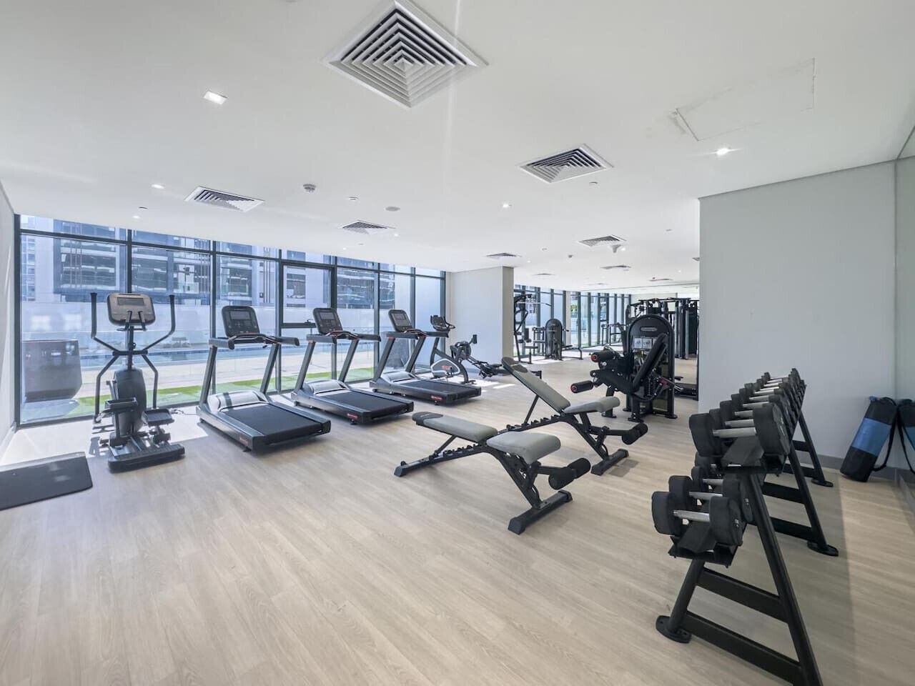 Et moderne fitnesscenter med løbebånd, vægtbænke og træningsudstyr.