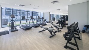 A modern gym with treadmills, weight benches, and exercise equipment.