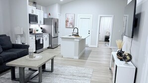 A modern living room with a sofa, coffee table, and a rug. - New construction 3-bedroom house in beautiful Midland with 2 car garage access. (Midland)
