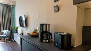 A kitchenette with a coffee maker, toaster, and a bowl of fruit on the counter. - Arbio I Duxen Apartments Hagenbeck Zoo (Hamburg)