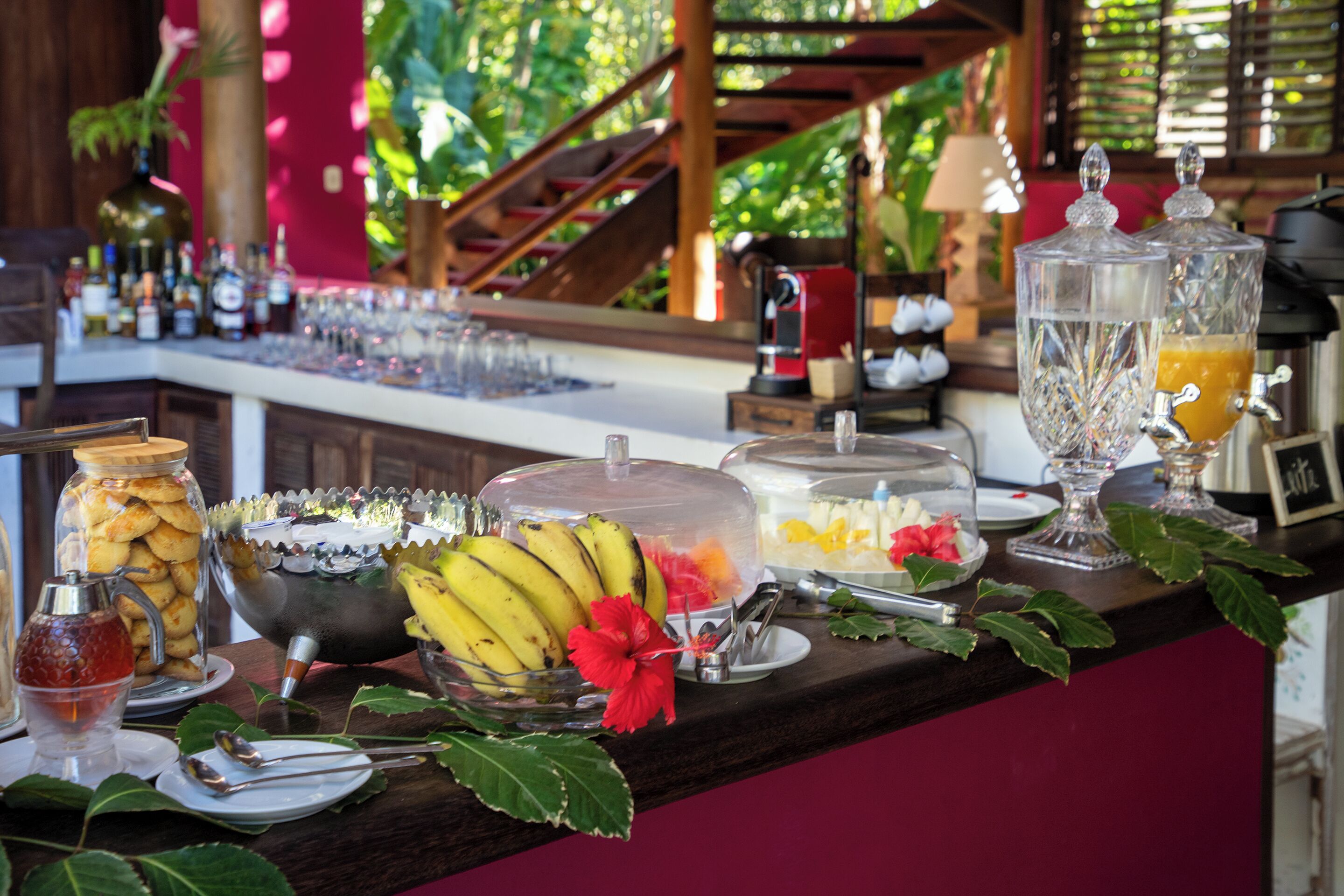 Zona de bar con diversas bebidas, un frutero y una máquina de café.